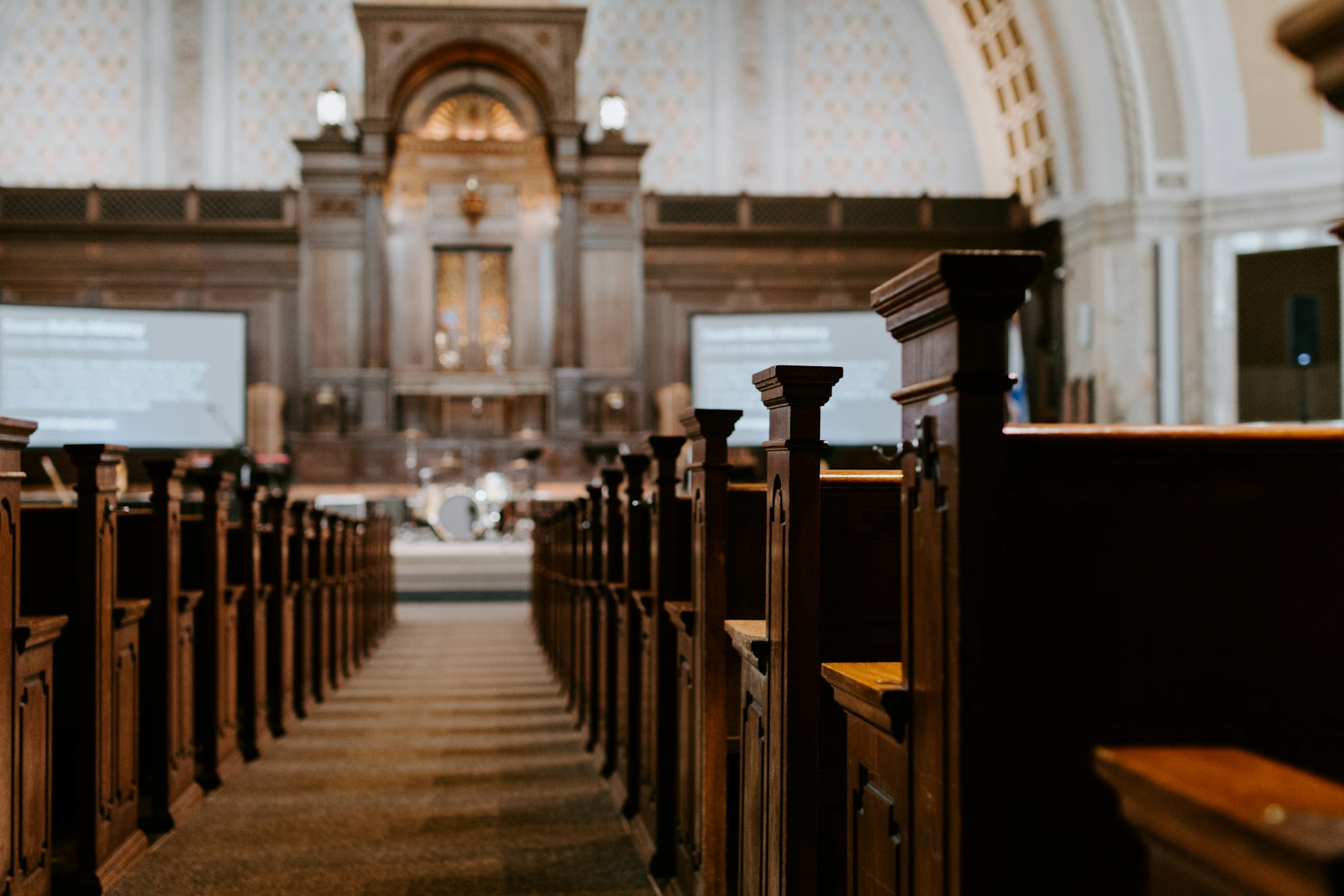 Church sanctuary interior with wooden pews facing the chancel